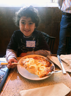 Sky Masori samples pizza he learned to make at Kavod Elementary School playdate