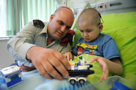 Maj. Maor Cohen on a private visit to Amit Zargarov, 7, in Dana-Dwek Children’s Hospital in Tel Aviv Sourasky Medical Center