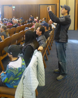 Mat Kostrinsky, a former City Council candidate, photographs his child during Temple Emanu-El festival