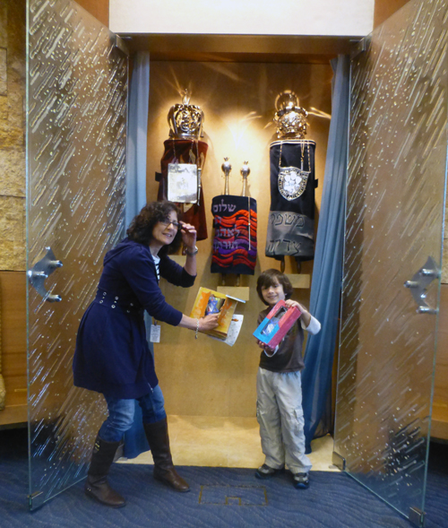 Skot Golden-Needham and his kindergarten teacher Lori Bunshaft show off aron kodesh models inside the real one at Temple Emanu-El