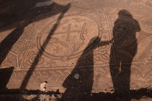 Observers' shadows contrast with mosaic cross on floor of Byzantine church (Photo: Yoli Shwartz, courtesy of the Israel Antiquities Authority)