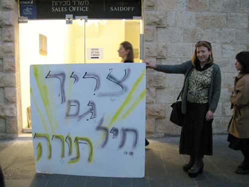 Haredi woman displays sign saying Torah soldiers are needed (Photo: Anat Silverman)