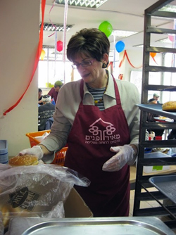 A volunteer at last year's Meir Panim Purim celebration in Israel. Once it raises the necessary funds, Meir Panim is planning a $12 million nutrition center in the southern Israeli town of Kiryat Gat. The current After School Youth Clubs of Meir Panim, meanwhile, reach thousands of at-risk youths. Credit: Courtesy Meir Panim.
