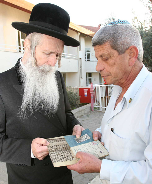 Rabbi Dovid Grossman receives Torah parchment, Nazi ID, from Moti Dotan (Photo courtesy of Migdal Ohr)