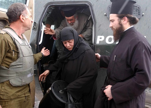 An Israeli soldier helps to smuggle out a priest and a nun from the Church of the Nativity in Bethlehem on April 7, 2002. That year, a siege by Palestinian militants on the Church of the Nativity persisted from April 2 to May 10—just days after Easter on the Eastern Orthodox calendar. Credit: Flash90.
