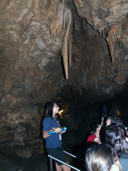 Melelani Correia stands under a stalactite in Lake Shasta Caverns