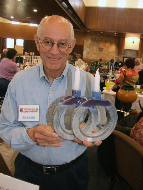 Norm Lurie holds two of his ceramic Shabbat candle holders.