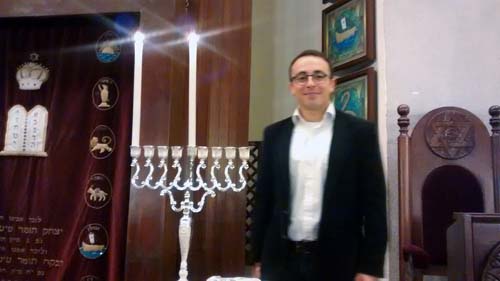 Mark Halawa on the first night of Chanukah in Tel Aviv's Great Synagogue. (Photo: Anav Silverman)
