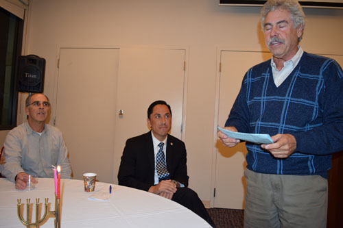 City Councilman Todd Gloria (middle) listens as Beth Israel Men's Club President Lou Galper reads a Chanukah message after lighting second night candle Dec. 17th. At left is Rob Rubin