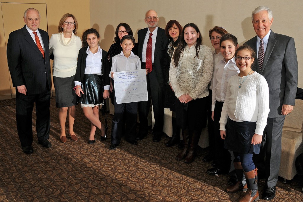 Malcolm Hoenlein, Executive Vice Chairman/CEO, Conference of Presidents, with Solomon Schechter school of Long Island staff and children who performed the song with (center) Alan Gross and (right) Robert G. Sugarman, Chairman, Conference of Presidents.