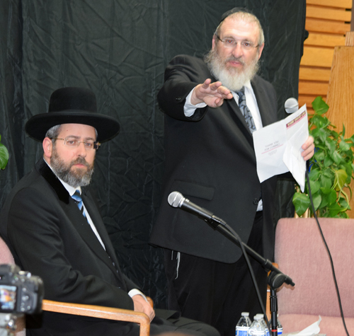 Chabad Rabbi Moishe Leider motions crowd to unoccupied chairs in front row as Israel's Chief Ashkenazic Rabbi David Lau, seated, observes.  (Photo: Donald H. Harrison)