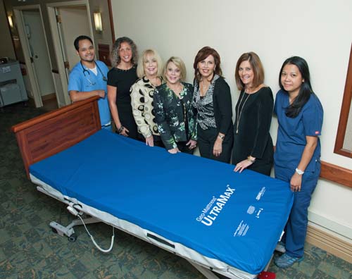 Samuel Ma, LVN (left); Kimberly Fuson, Vice President of Operations; Sharon Letter Kaplan, Gala Steering Committee Member; Rusti Bartell Weiss, 2015 Gala Chair; Mary Epsten, President of Women’s Auxiliary; Pam Ferris, President/CEO and Leonida Hernandez, RN/MDS Coordinator with the sample bed for the 2015 Fund-a-Need project to raise funds for 60 medical-surgical beds and mattresses for the Joseph & Dorothy Goldberg Healthcare Center.  