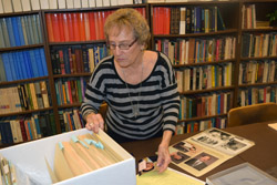 Gerri Brech files photos in archival boxes