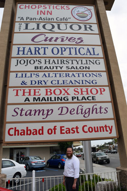 Rabbi Rafi Andrusier stands below shopping center marquis in La Mesa