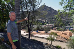 Marty Stroh points to a hill that was completely engulfed in flames