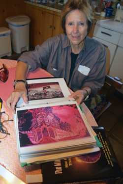 Catherine Hand displays a photo of one of the 60 x 35 foot backdrops she designed for a production of the Nutcracker