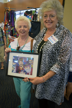 Mickey Klaus, a friend of the artist, poses with print she likes by artist Marlene Parker Korey