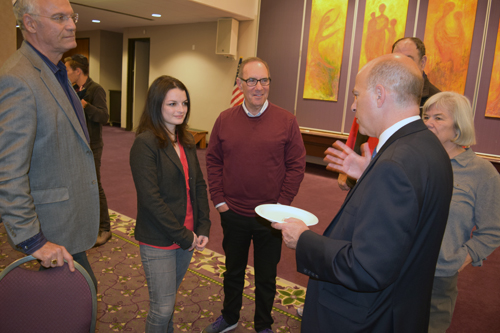 Eric Birnbaum, right, schmoozes following his speech with some members and guests of the Men's Club of Tifereth Israel Synagogue