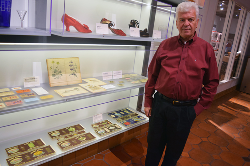 San Diego History Center Executive Director Bill Lawrence poses by a current exhibit that perhaps could be used in the upcoming Jewish exhibition: canned products packaged and distributed in the early 20th century by the Jewish-owned Klauber Wangenheim Company.