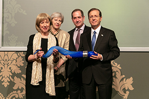From left, Lady Elaine Sacks, former Prime Minister of the United Kingdom Theresa May, Genesis Prize Foundation Co-founder and Chairman Stan Polovets, President of Israel Isaac Herzog. (Photo: Thomas Alexander/ Genesis Prize Foundation)